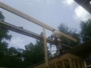 Carpenter setting a ridge beam over a new addition frame — Ice Dam Removal by Roofing Brothers in Manly
